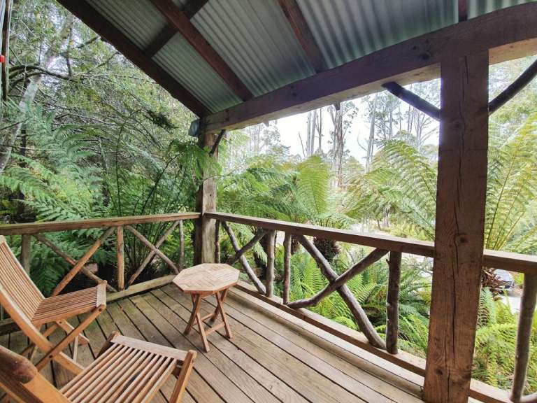 Ein Holzdeck mit Stühlen und einem Tisch darauf