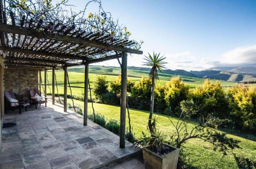 Eine Person sitzt auf einer Veranda mit Blick auf die Berge
