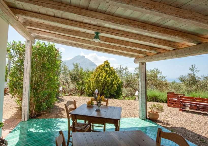 Ein Tisch und Stühle auf einer Veranda mit Blick auf einen Berg