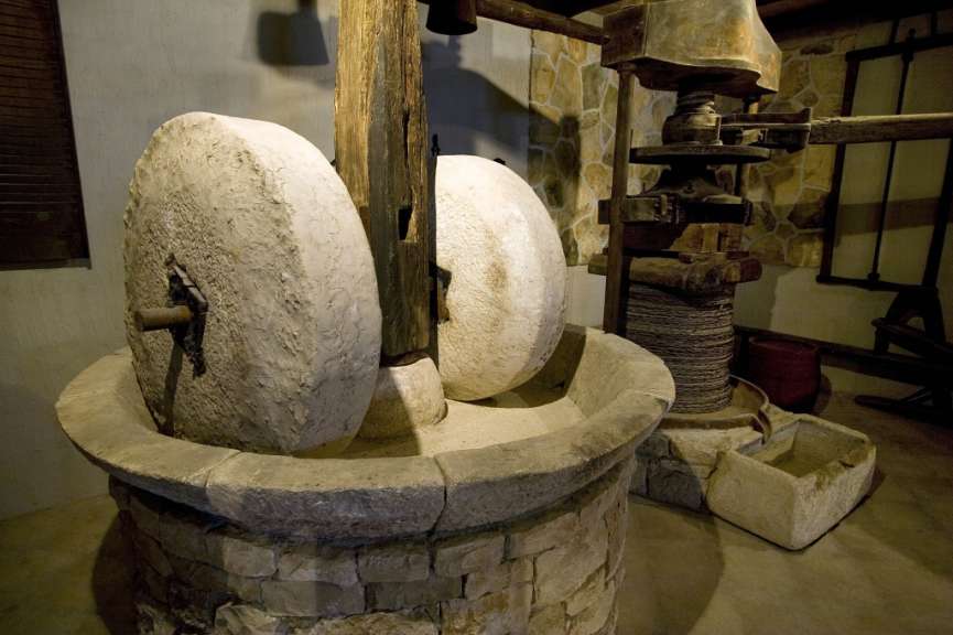 Eine alte Ölmühle mit Steinrädern und einem Holzgestell
