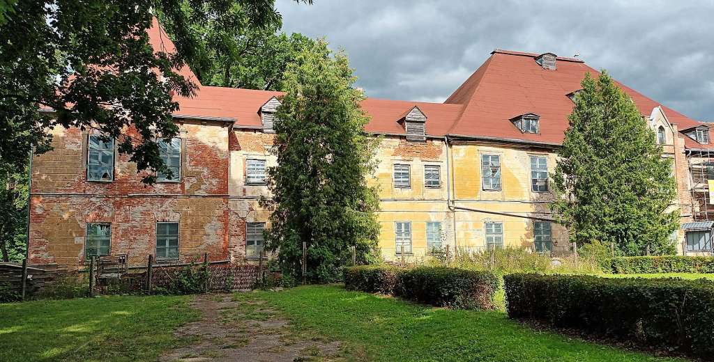 Ein sehr altes Gebäude mit einem roten Dach und vielen Fenstern