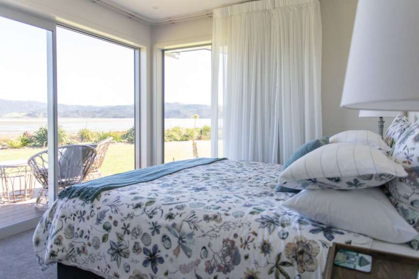 Ein Schlafzimmer mit einem Bett und einem Fenster mit Blick auf einen See