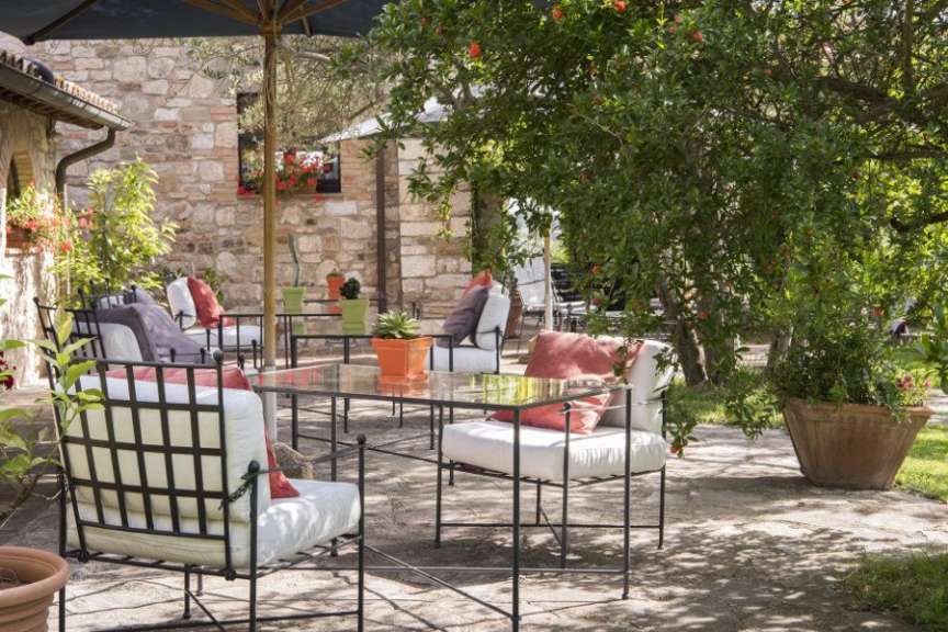 Eine Terrasse mit einem Tisch und Stühlen und einem Regenschirm