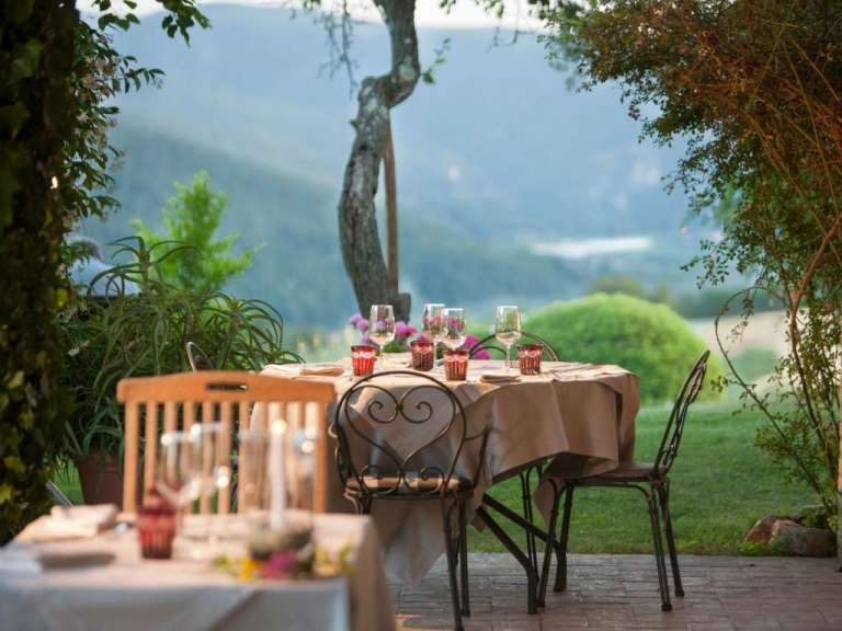 Ein Tisch und Stühle auf einer Terrasse mit Blick auf die Berge