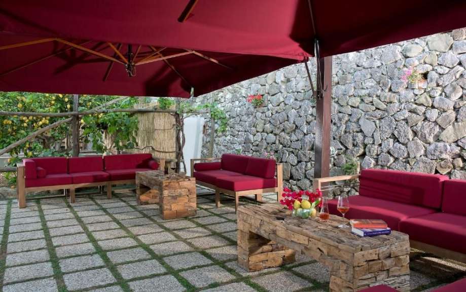 Eine Terrasse mit roten Möbeln und einem roten Regenschirm