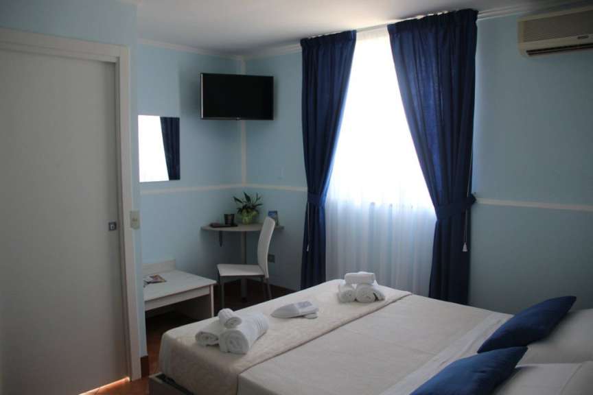 Ein Schlafzimmer mit einem Bett und einem Fernseher an der Wand