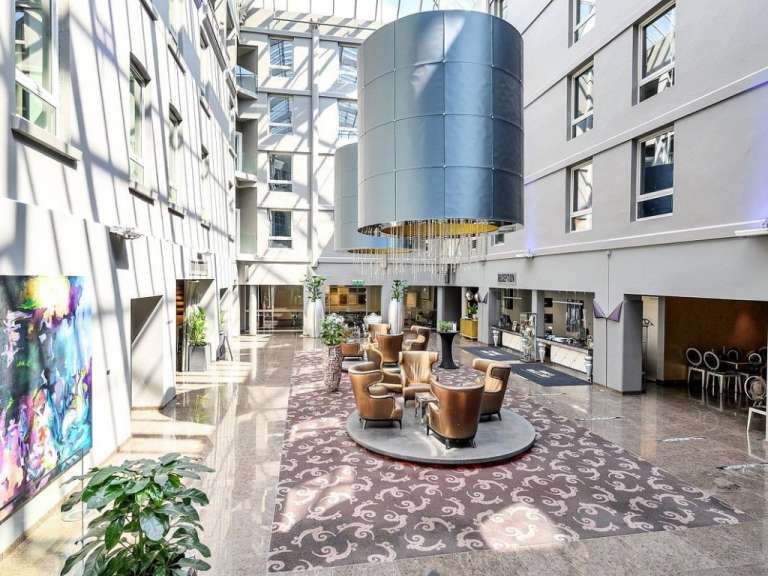 Ein Hotelflur mit vielen Stühlen und einem großen Kronleuchter
