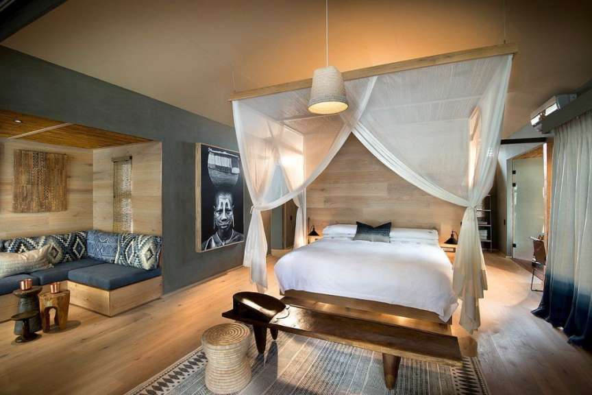 Ein Schlafzimmer mit einem Himmelbett und einem Gemälde an der Wand