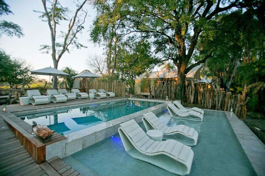 Liegestühle und Sonnenschirme umgeben einen großen Swimmingpool