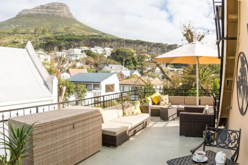 Ein Balkon mit Möbeln und einem Sonnenschirm mit einem Berg im Hintergrund