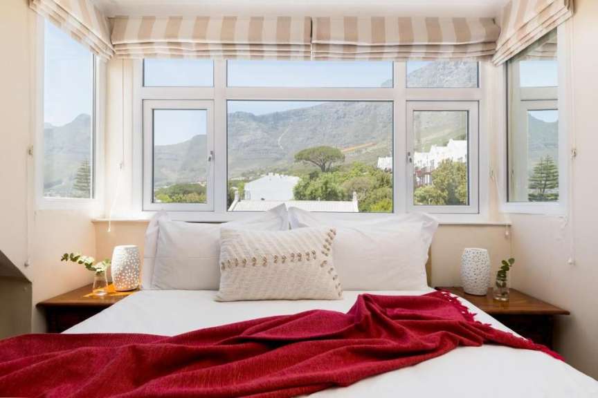 Ein Schlafzimmer mit einem Bett und einem Fenster mit Blick auf die Berge