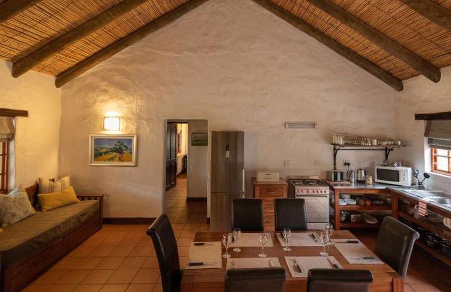 Ein Esszimmer mit einem Tisch und Stühlen und einem Gemälde an der Wand