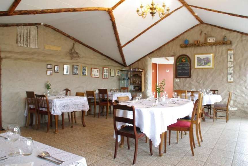 Ein Speisesaal mit weißen Tischen und Stühlen