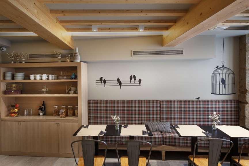 Ein Restaurant mit Tisch und Stühlen und einem Vogelkäfig an der Wand