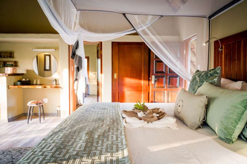Ein Schlafzimmer mit einem Himmelbett und einem Spiegel