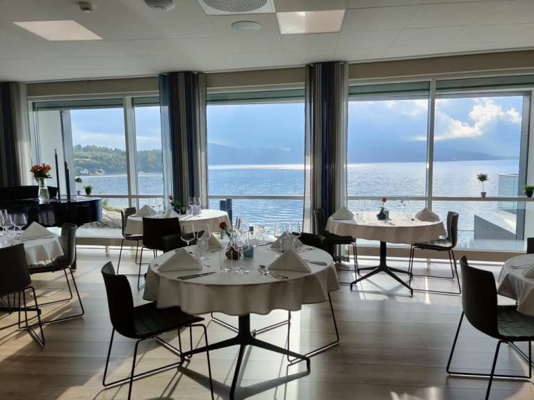 Tische und Stühle in einem Restaurant mit Blick auf den Ozean