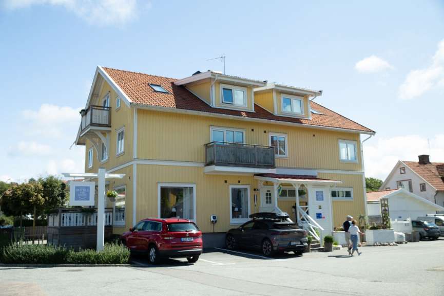 Ein gelbes Haus mit einem roten Auto vorne geparkt