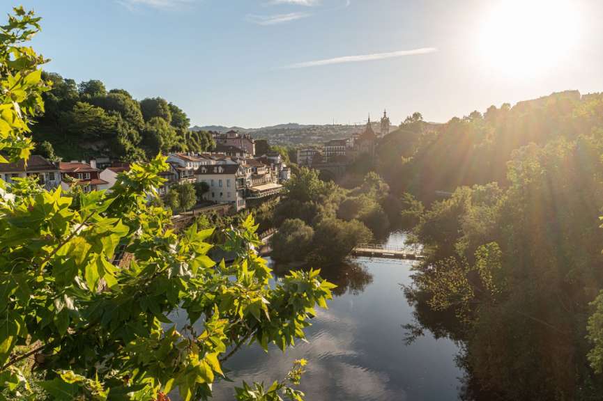 Die Sonne scheint durch die Bäume über einen Fluss