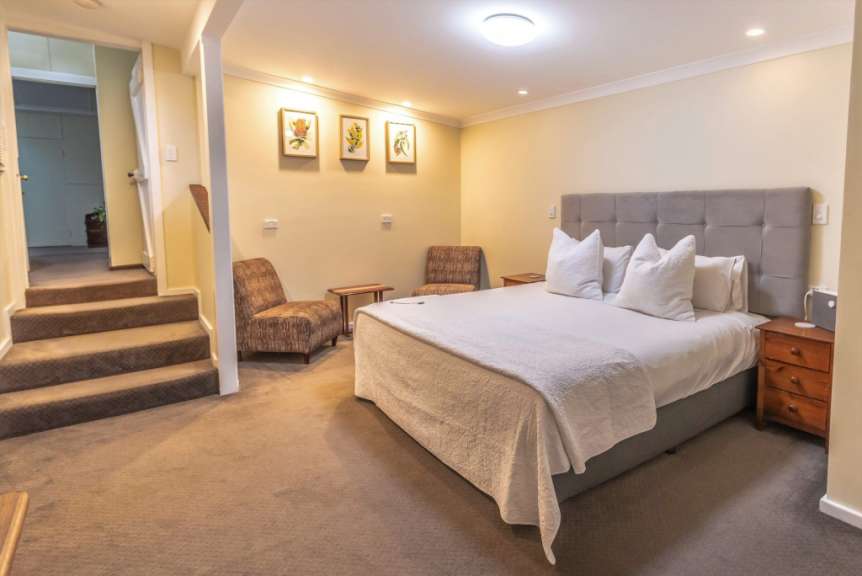 Ein Schlafzimmer mit einem Kingsize-Bett und zwei Stühlen