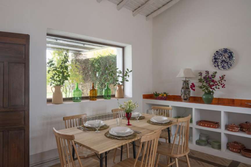 Ein Esszimmer mit einem Tisch und Stühlen und einem Fenster