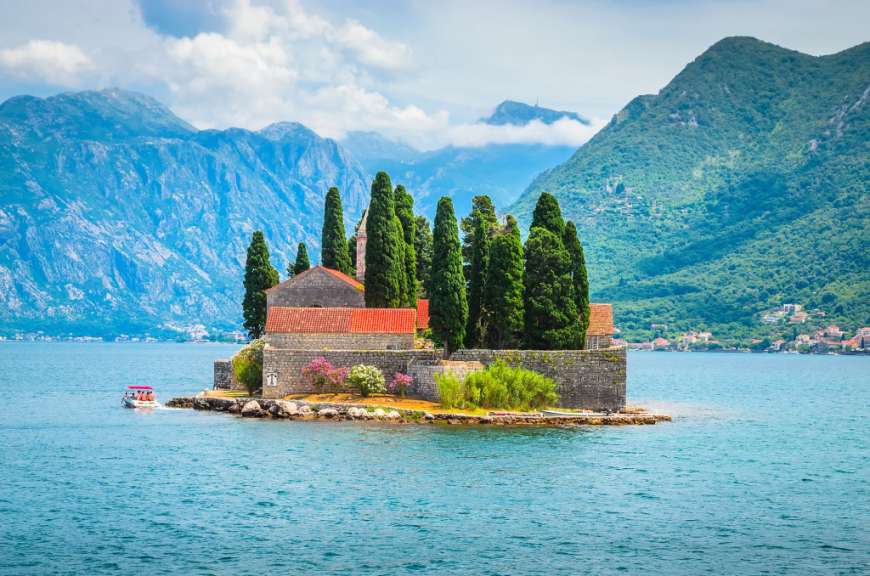 Eine kleine Insel mit einer Kirche und Bäumen inmitten eines Sees