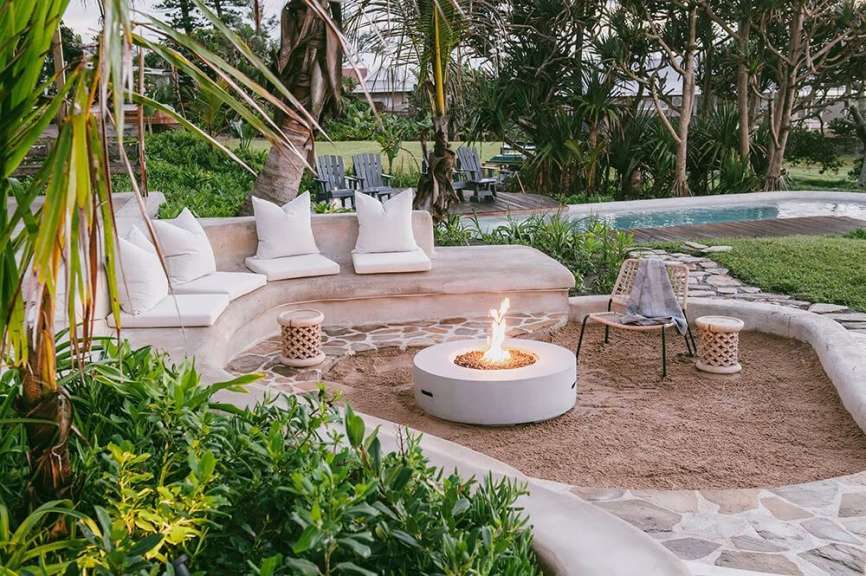 Ein weißer Feuerplatz in einem Garten neben einer Couch