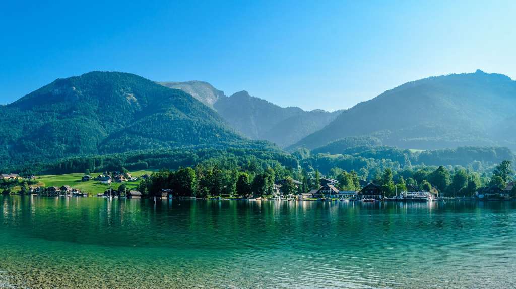 Ein See mit Bäumen und Bergen im Hintergrund