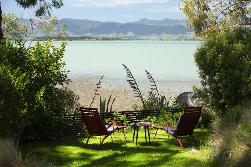 Ein Tisch und Stühle stehen auf einer Wiese mit Blick auf einen See
