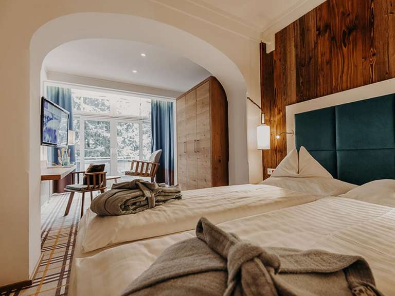 Ein Hotelzimmer mit zwei Betten, einem Schreibtisch und einem Fernseher.