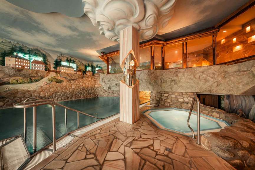 Im Innenbereich befindet sich ein Spa-Bereich mit einem Schwimmbecken, einem Whirlpool und einer Steinwanddekoration sowie einer Deckenmalerei.