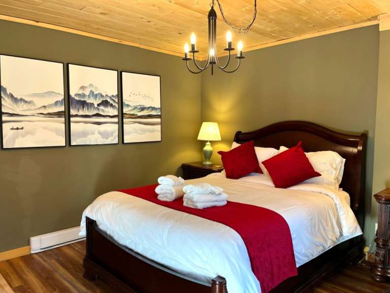 Ein Schlafzimmer mit einem Bett und drei Gemälden an der Wand