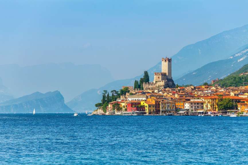 Eine Stadt am Ufer eines Sees mit Bergen im Hintergrund