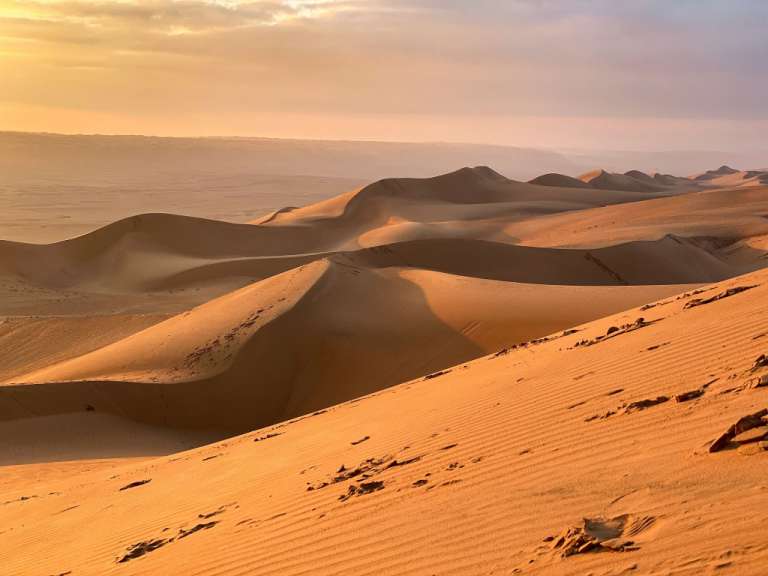 Eine Wüste mit vielen Sanddünen an einem bewölkten Tag