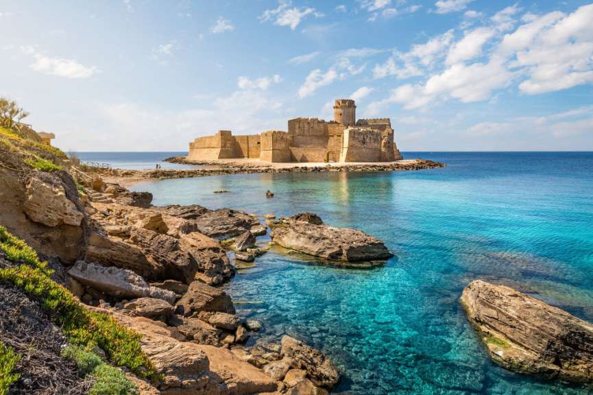 Ein großes Schloss sitzt auf einer kleinen Insel im Ozean