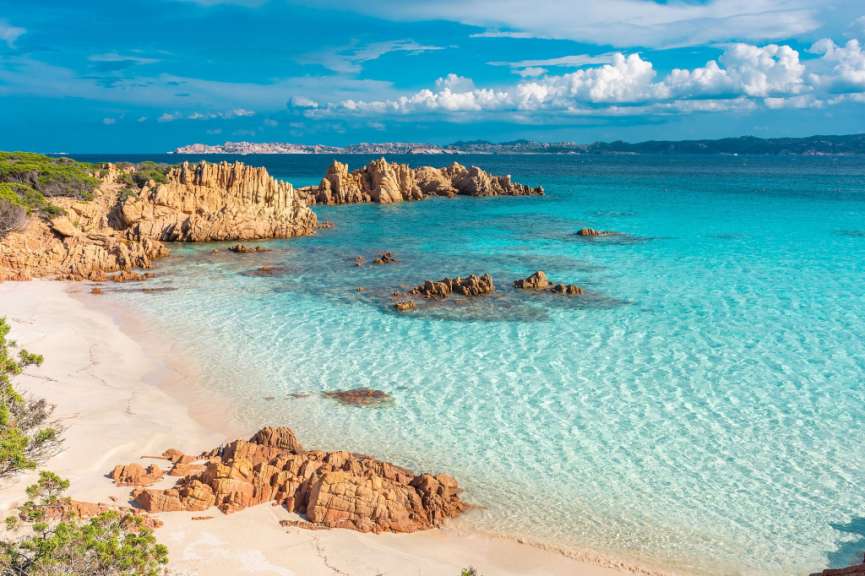 Ein Strand mit weißem Sand und blauem Wasser