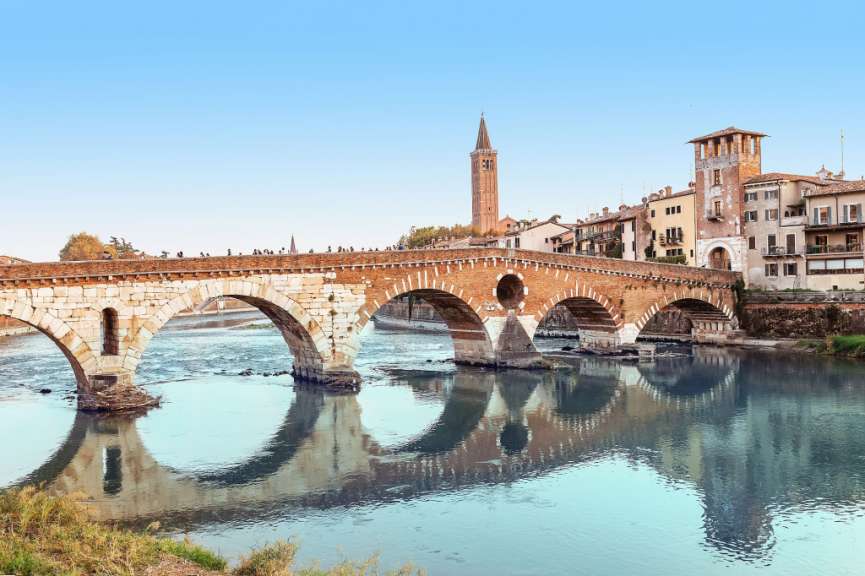 Eine Brücke über einen Fluss mit einem Turm im Hintergrund