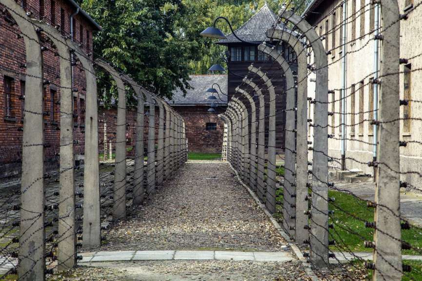 Ein Stacheldrahtzaun führt zu einem Gebäude