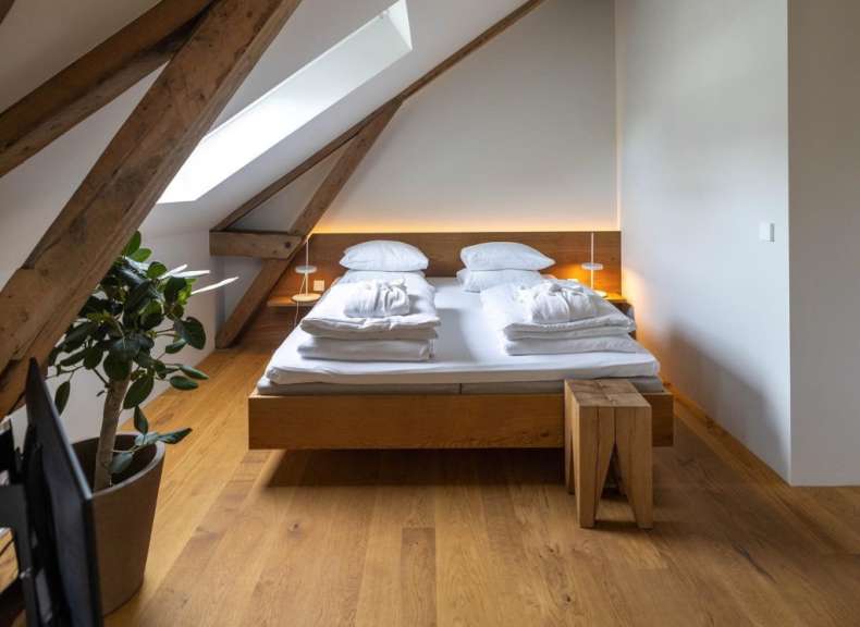 Ein Schlafzimmer mit einem Holzbett und einem Holzhocker