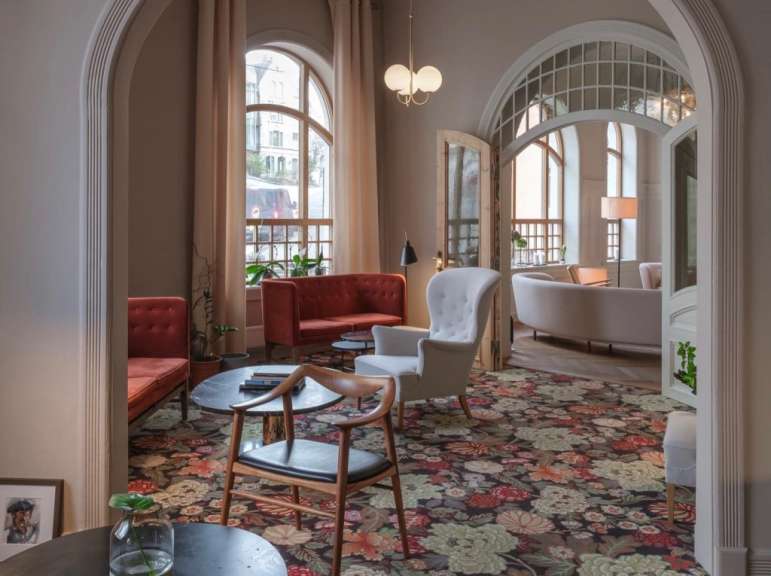 Ein Wohnzimmer mit vielen Möbeln und einem Blumenteppich