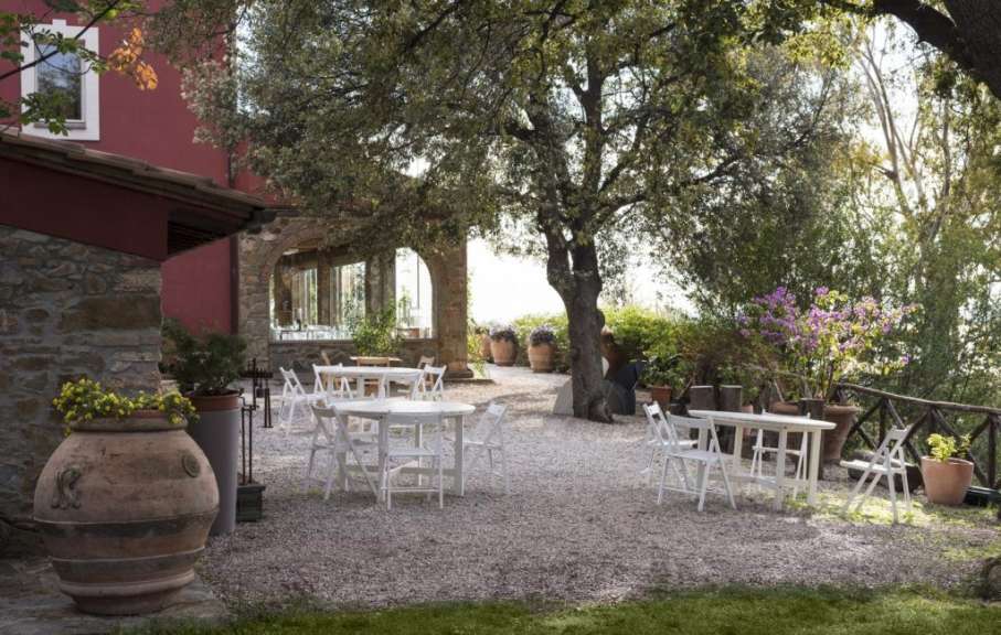 Eine Reihe von weißen Stühlen und Tischen in einem Garten