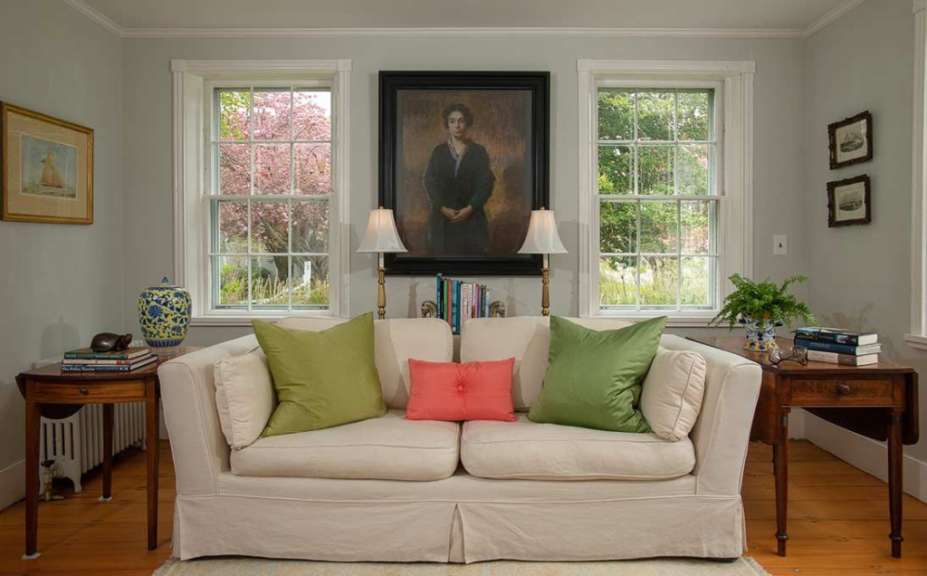 Ein Wohnzimmer mit einem weißen Couch und einem Gemälde an der Wand