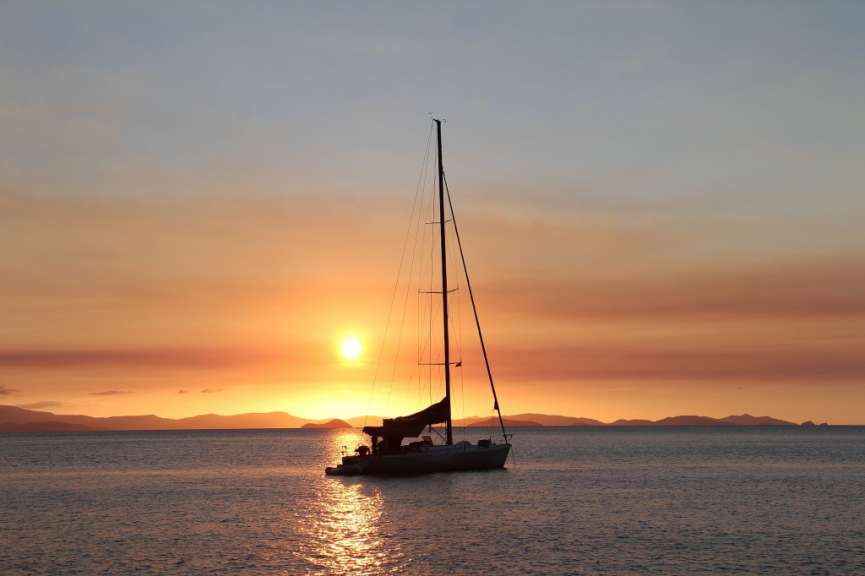 Ein Segelboot im Ozean bei Sonnenuntergang