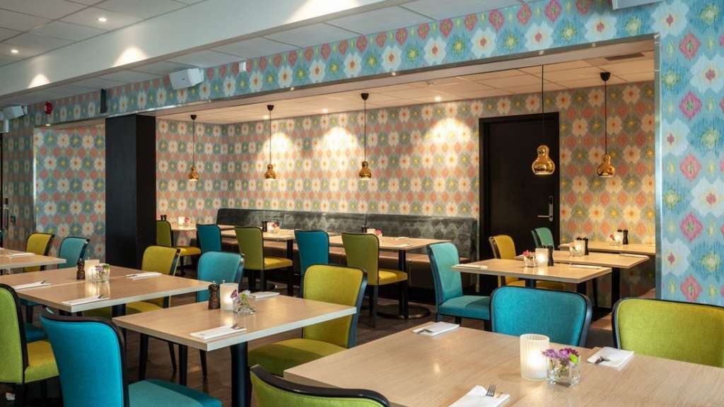 Tische und Stühle in einem Restaurant mit bunten Wänden