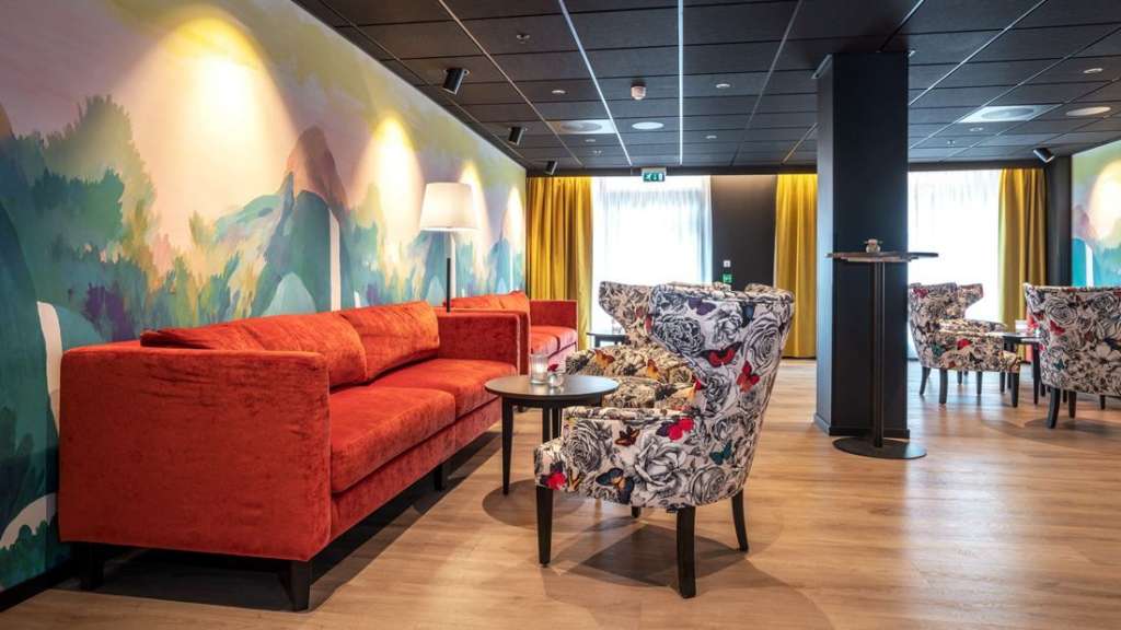 Ein Wohnzimmer mit roten Sofas und bunten Stühlen