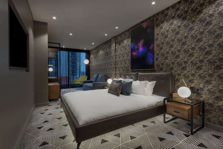 Ein Hotelzimmer mit einem großen Bett und einem Gemälde an der Wand