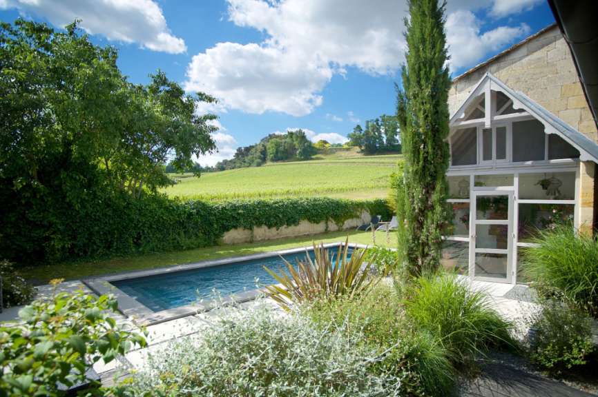 Ein Haus mit einem Pool und einem Weinberg im Hintergrund