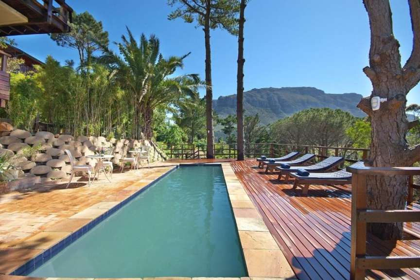 Ein schwimmbad mit einem holzdeck und einem berg im hintergrund