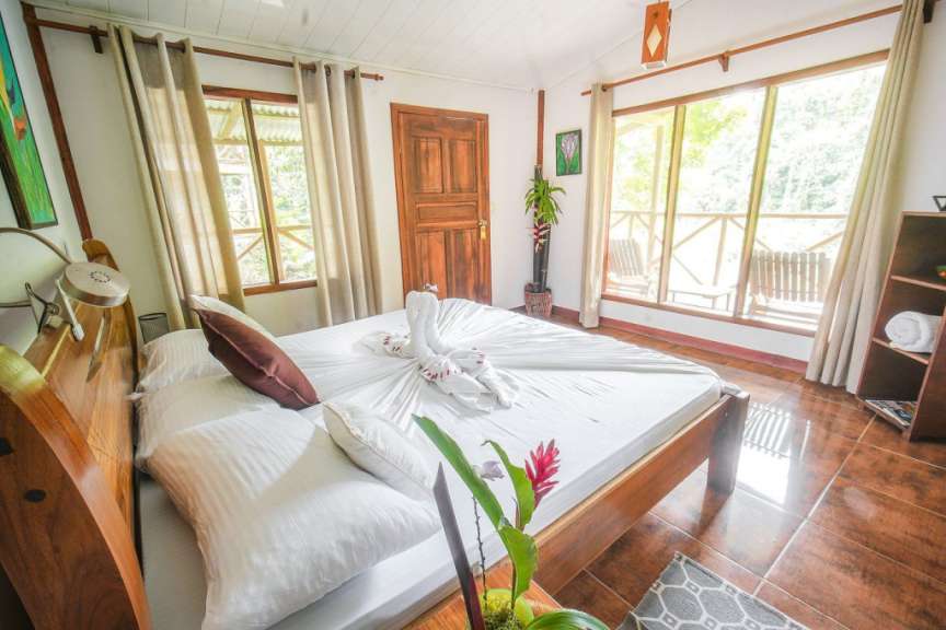 Ein Schlafzimmer mit einem Bett und vielen Fenstern