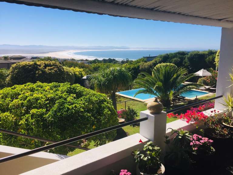 Ein Balkon mit Blick auf einen Pool und das Meer