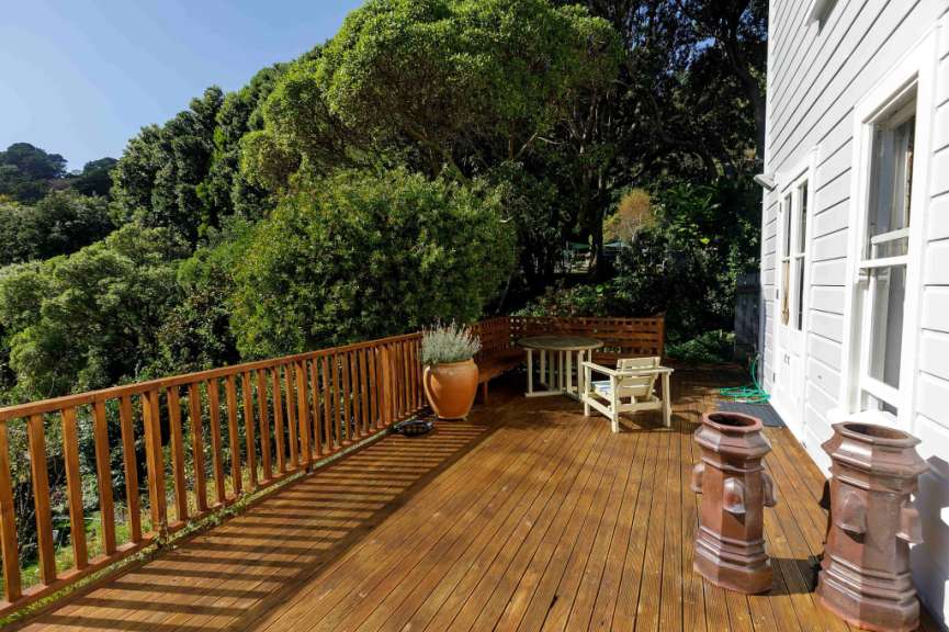 Ein Holzdeck mit einem Tisch und Stühlen darauf